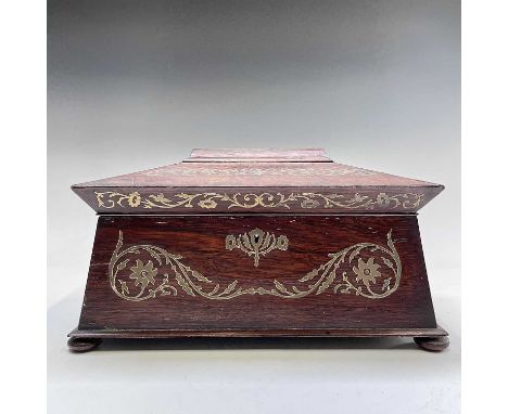 A Regency rosewood and cut brass inlaid tea caddy of sarcophagus form, the lid opening to reveal two lidded compartments init