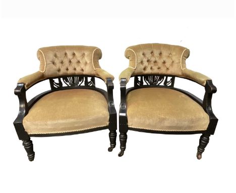 A pair of Victorian ebonised tub chairs, with button upholstered backs above narrow carved and pierced splats, on turned fron