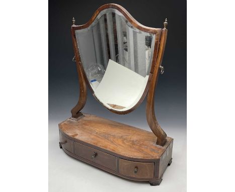 A late George III mahogany shield shape dressing table mirror, the rosewood banded bow front base fitted with three drawers, 