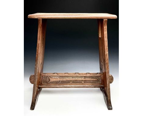 An Edwardian walnut stool, with a narrow padded top on tapered supports, carved with a harp design, height 59cm, width 53cm, 