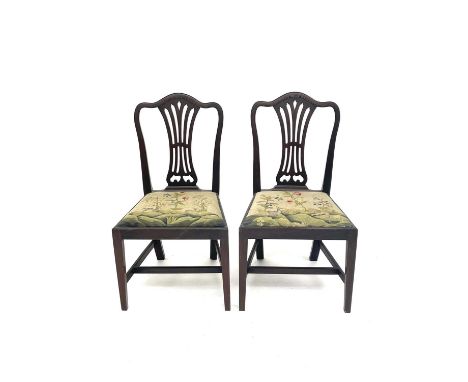 A pair of George III mahogany dining chairs, in the Chippendale style, with pierced vase splats, the drop-in seats embroidere
