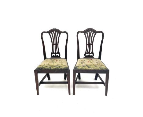 A pair of George III mahogany dining chairs, in the Chippendale style, with pierced vase splats, the drop-in seats embroidere