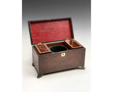 A late George III mahogany and chequer inlaid tea caddy, the interior with two lidded compartments and raised on brass paw fe
