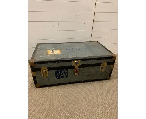 A vintage travel trunk with leather handles and brass corners 