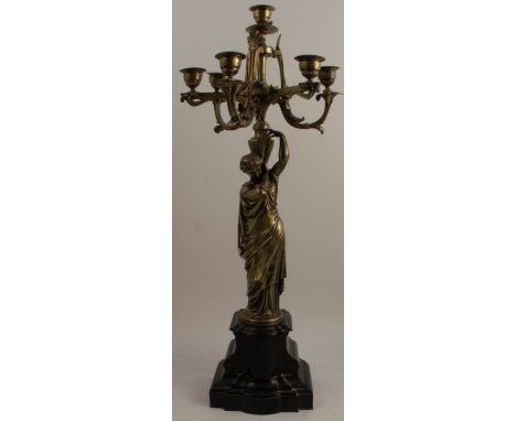 A 19th century gilt metal five light candelabrum, the Aesthic style branches supported by a female figure, on a black marble 