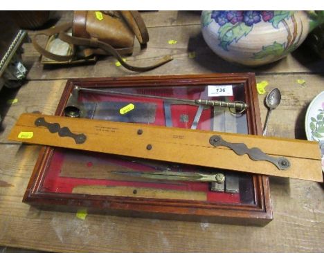A mahogany and glass display case, containing various brass, steel and wood tools, together with other tools
