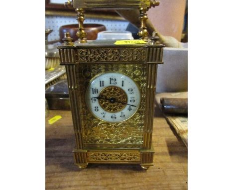A gilt metal cased carriage clock, with enamel chapter ring and pierced decoration, height including handle 6ins