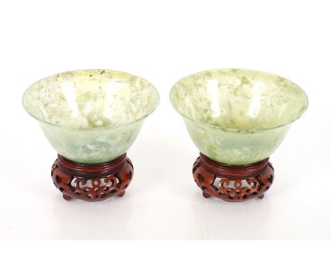 A pair of Chinese green jade bowls on stands, cased