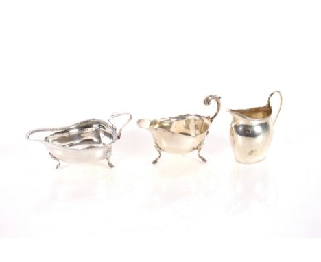 A George V silver cream jug, with gadrooned border and angular handle raised on three hoof feet, London 1915; a silver cream 