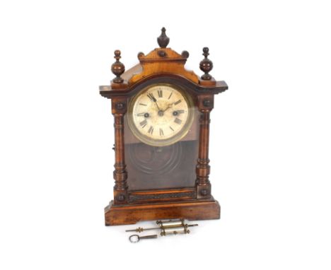 A late 19th Century walnut cased mantel clock, with adjustable pendulum, 8 day movement striking on a gong 