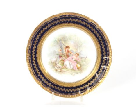 A hand painted 19th Century Limoges cabinet plate, decorated with a pastoral scene, having gilded blue ground border, 25cm di