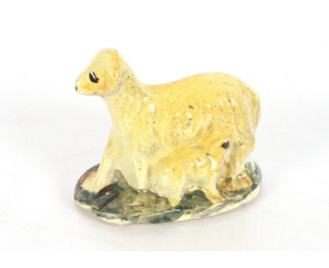 An early 19th Century Prattware figure of a dog and her puppy, 7.5cm long