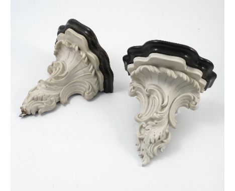 A pair of 19th century marble and stained wood wall brackets, the marble asymmetrically carved with scrolls and leaves, with 