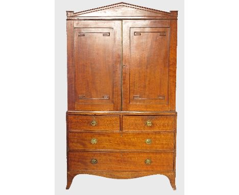 A late Georgian mahogany linen press, the upper section fitted with two panelled doors, fitted two short drawers over two lon