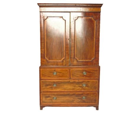A late Georgian mahogany linen press, having two satinwood cross banded panels to the upper section, opening to reveal four s