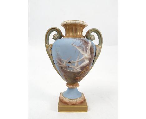 A Royal Worcester pedestal vase, decorated with swans to a powder blue ground, by C H C Baldwyn, to scroll handles, shape num