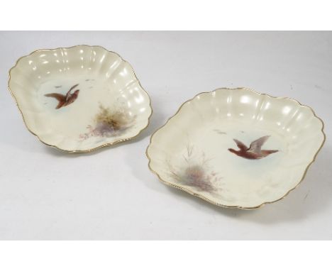 A pair of Royal Worcester square dishes, painted with different game birds in flight by Jas Stinton, with shaped borders, dat