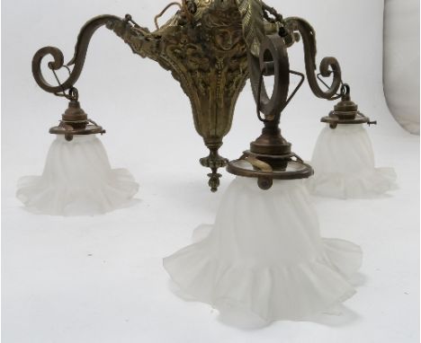 A gilt metal ceiling light, the central hanging pendant having three leaf and scroll arms with three pressed frosted glass sh