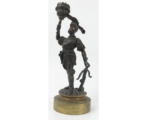 A 19th century bronzed candlestick, formed as a soldier in armour holding the sconce, with cross bow in the other hand, raise