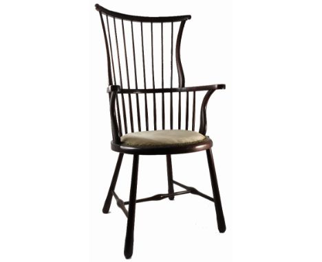 An Edwardian high comb back windsor armchair, on turned legs united by stretcher
