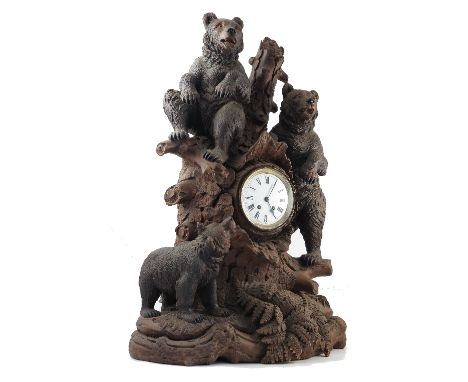 A large Black Forest bear carved wooden clock, the Lenzkirch striking movement stamped 451874, with white enamel dial and Rom
