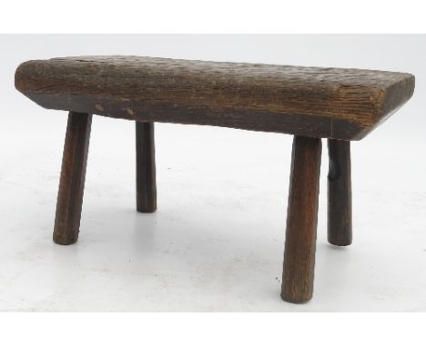 A primitive oak rectangular stool, raised on four legs, width 19.75ins