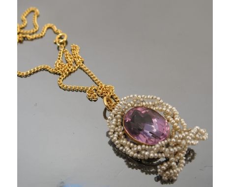 An amethyst pendant, the oval cut enclosed by seed pearls, on a chain 