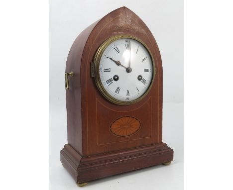 A mahogany cased striking mantel clock, with white enamel dial and Roman numerals, the arched case with satinwood inlay and r