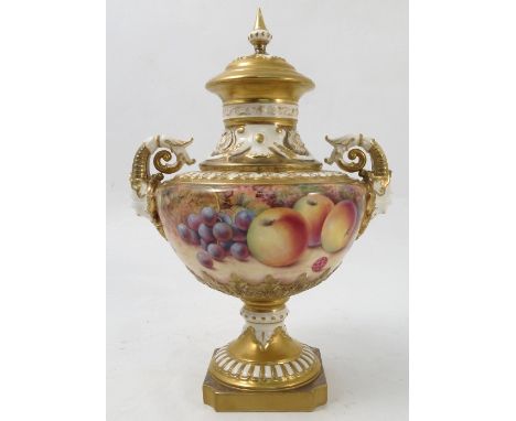 A Royal Worcester covered pedestal vase, hand painted all around with fruit to a mossy background by P Platt, with mask and s