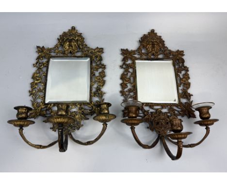 A PAIR OF GILDED METAL GIRANDOLE WALL MIRRORS WITH GREEN MAN MASKS AND DOLPHINS48cm x 26cm each.