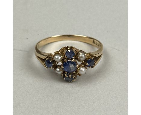 AN 18CT GOLD RING SET WITH BLUE STONES AND SEED PEARLSWeight: 2.7gms