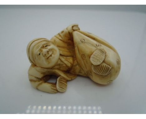 Japanese ivory Netsuke of man lying with bag, approx 21.5g