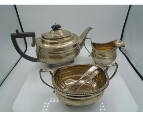 Silver three-piece tea service by Mappin &amp; Webb comprising oval teapot with ebonised handle and lid knob, two handled sug