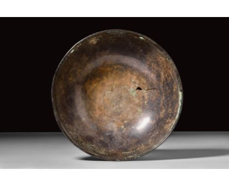 Ca. 5th century BC. A bronze bowl with a hemispherical body and a slightly pronounced rim. The bottom of the basin features a
