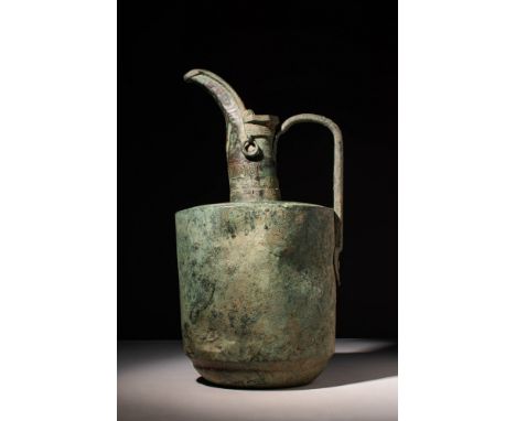 Ca. AD 900 - 1100. A stunning Seljuk bronze ewer with a cylindrical body connected to flat shoulders leading to a narrow tubu