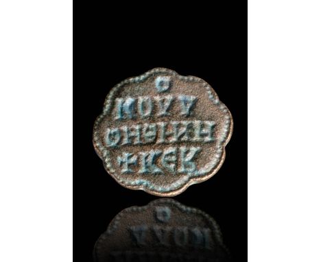 Ca. AD 800 - 1200.A Byzantine stamp seal with a flower-shaped bezel inscribed with Greek letters. The inscription is in four 