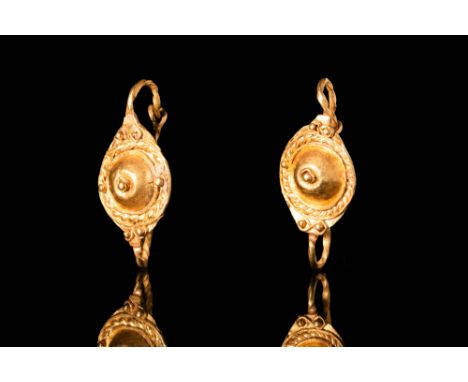 Ca. AD 200 - 300. A pair of Roman gold earrings. Each has a large bezel with a central dot set in a circle of filigree and co