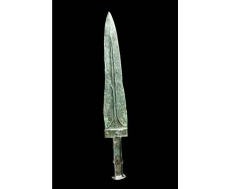 Ca. 1200 - 700 BC.A bronze short sword with a triangular double-edged blade. There are decorative and structural ribbing on t
