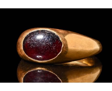 Ca. AD 400. An oval-shaped carnelian intaglio engraved with a nude male figure seated atop a pile of rocks. He holds a stick 