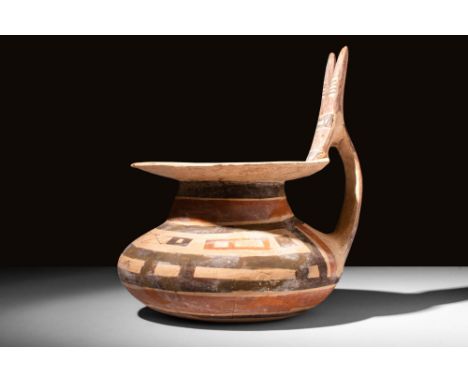 Ca. 550 - 400 BC.A rare Daunian ceramic vessel with a deep funnel-shaped neck and a loop handle on the shoulder. It has a ver
