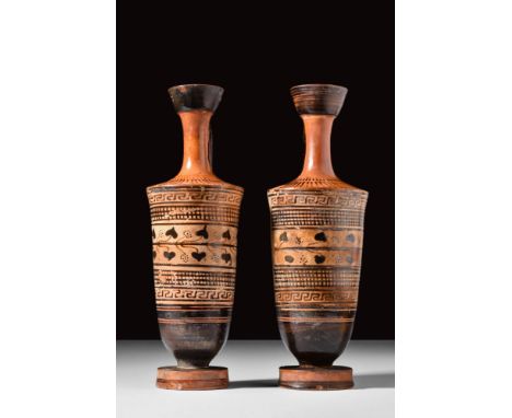 Ca. 500 - 450 BC. A pair of terracotta lekythoi, each with flared neck and loop handles above black bands of foliage and cros