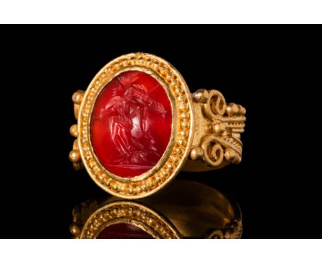Ca. 100 BC - 50 AD. A Roman intaglio depicting a soldier holding a dead body. The intaglio is set in a 21ct, possibly later g