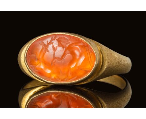 Ca. AD 100 - 300.A stunning Roman gold ring with D section hoop enlarged on the soulders to form an oval bezel securing an he