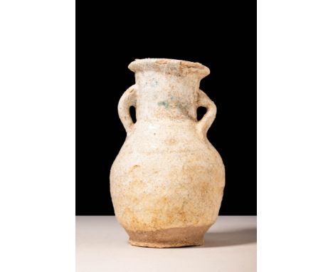 Ca. 30 BC - AD 200.A Romano-Egyptian cream faience Amphoriskos. The apple-shaped body rises and expands upwards from the flat