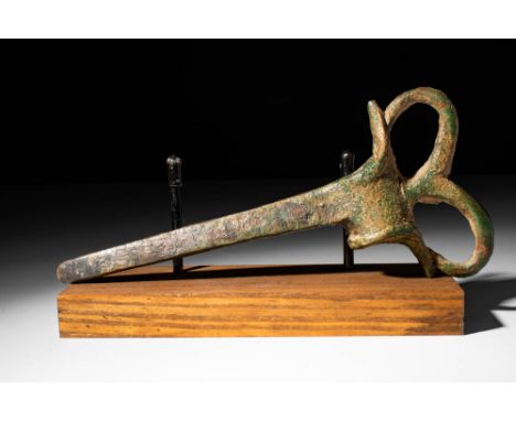 Ca. 1200 - 800 BC. A bronze socketed axe head with a circular socketing hole, a slender pickaxe-like blade, and a reverse sid