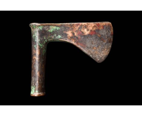 Ca. 1500-1000 BC.A cast bronze axe head featuring a cylindrical shaft and a bearded blade that terminates in a convex cutting