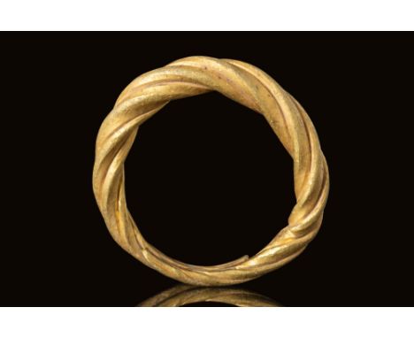 Ca. AD 800 - 1100. A Viking ring made of twisted gold bands. The ring features thick intertwining bands which gradually taper