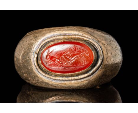 Ca. AD 100 - 300. A Roman silver ring with a D-section hoop expanding on the shoulders to house an oval carnelian gemstone in