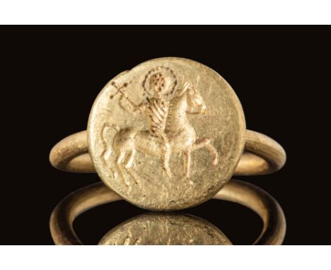 Ca. AD 500 - 700.A rare Byzantine gold ring with a cylindrical round hoop connected to a circular bezel embellished with an a