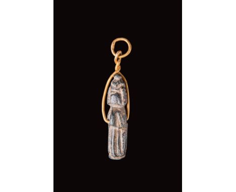 Ca. 3000 - 2000 BC. A Mesopotamian green stone amulet representing a standing goddess wearing a long robe pierced in the midd